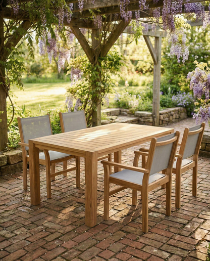 Outdoor wooden dining set with chairs on a brick patio under a wisteria-covered pergola.