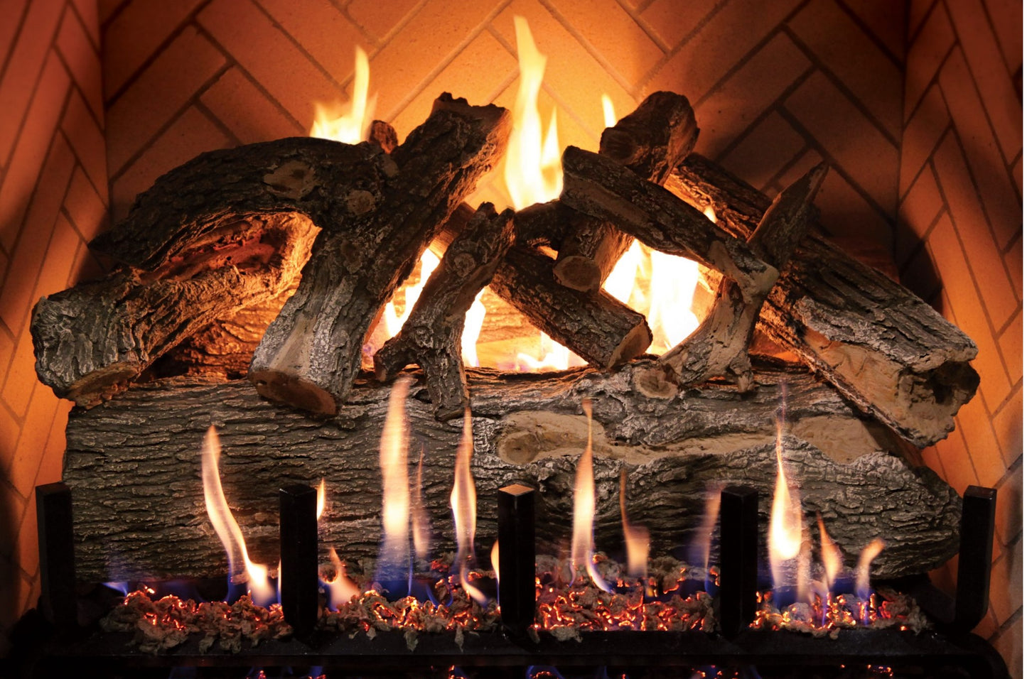 Fireplace with burning logs and flames against a wooden wall.