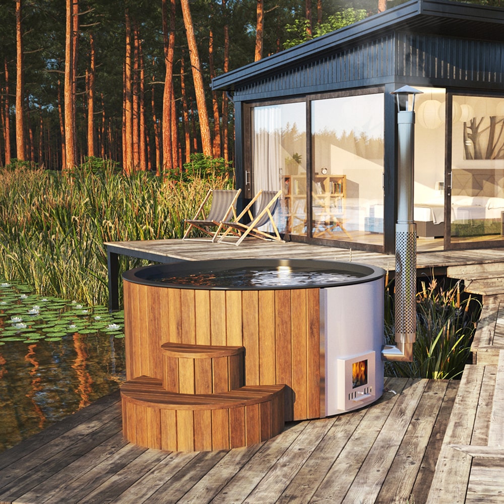 Wooden hot tub on a wooden deck by a modern cabin in the woods.